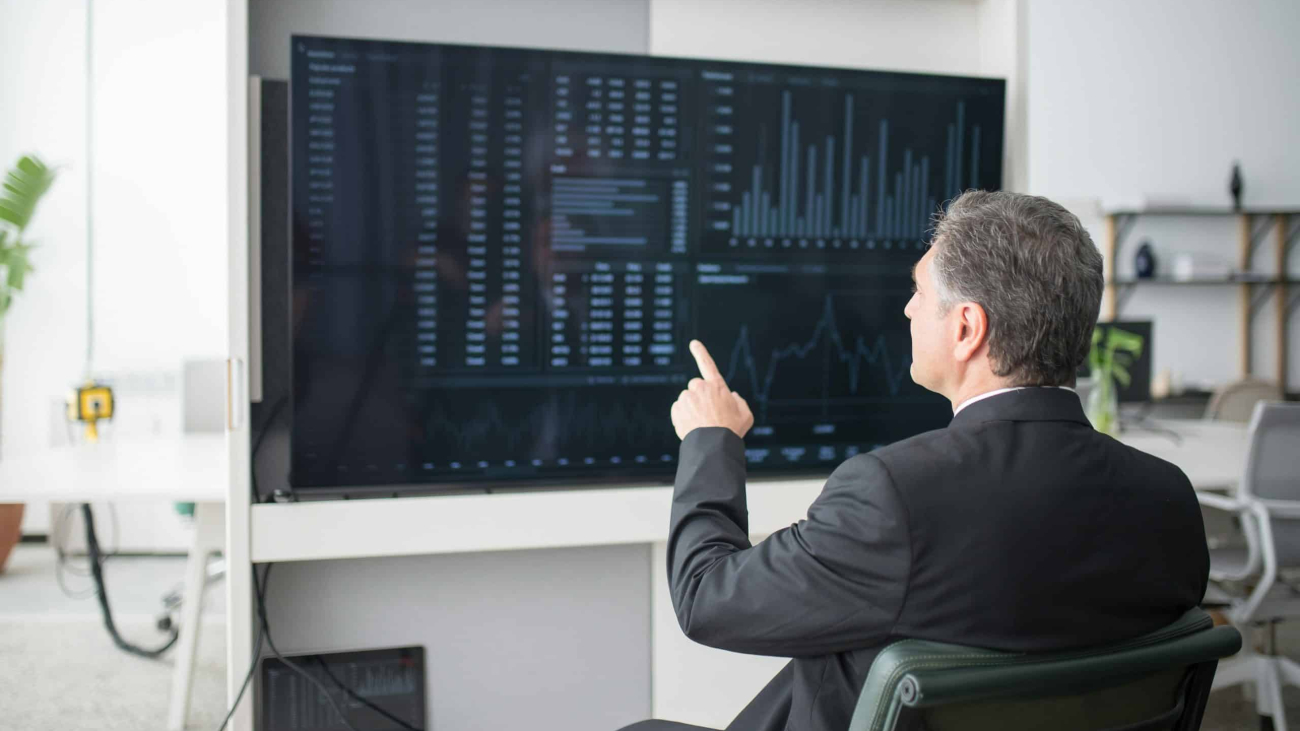 A man pointing at a screen showing analytics